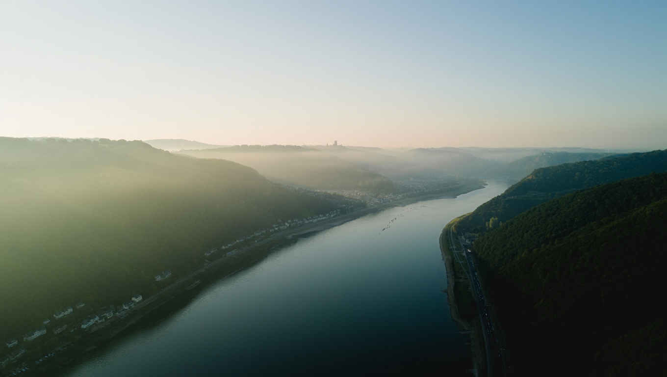 Panoramablick über das Rheintal bei Morgengrauen — sanfter Nebel über dem Fluss
